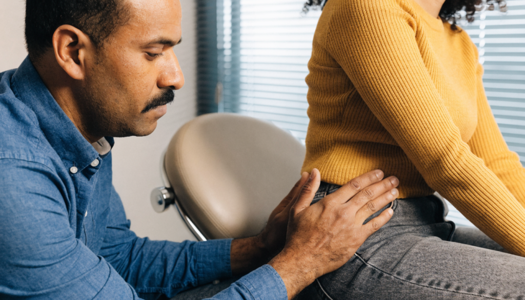 Closeup of a urologist examining a patient’s pelvic area with focus on a calm, professional hands-on gesture