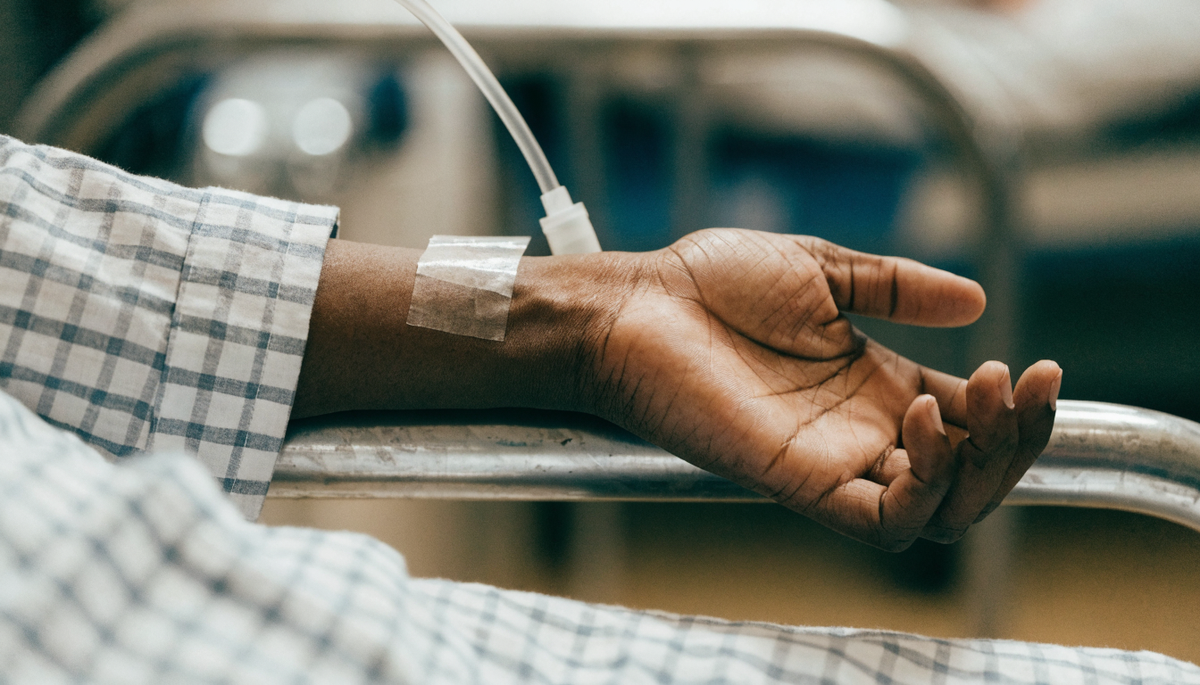 Closeup of a patient’s hand resting on a hospital bed rail, conveying comfort and relief after treatment