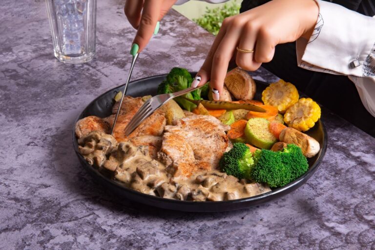10 Dîners Protéinés Faciles et Légers Pour le Soir | Santé et bien-être Close-up of a delicious grilled chicken dish with colorful vegetables on a dining table.