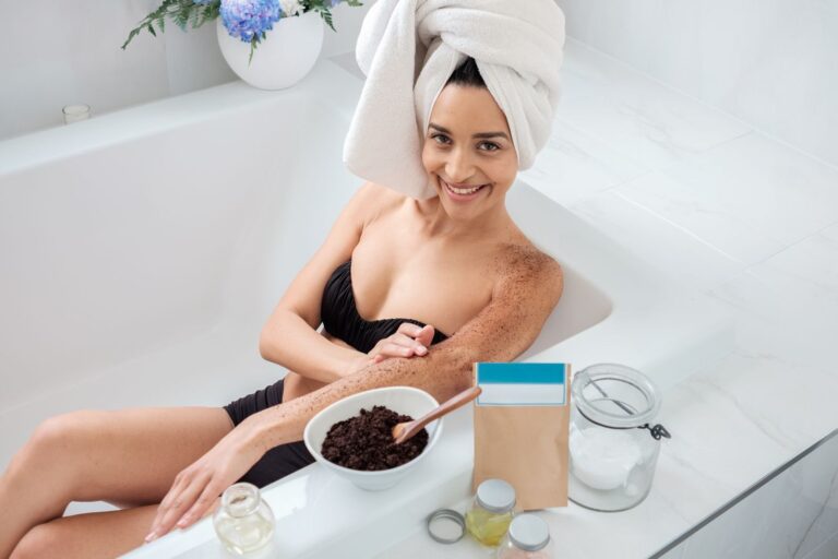 A smiling woman enjoys a bath with skincare products, showcasing a relaxing self-care routine.