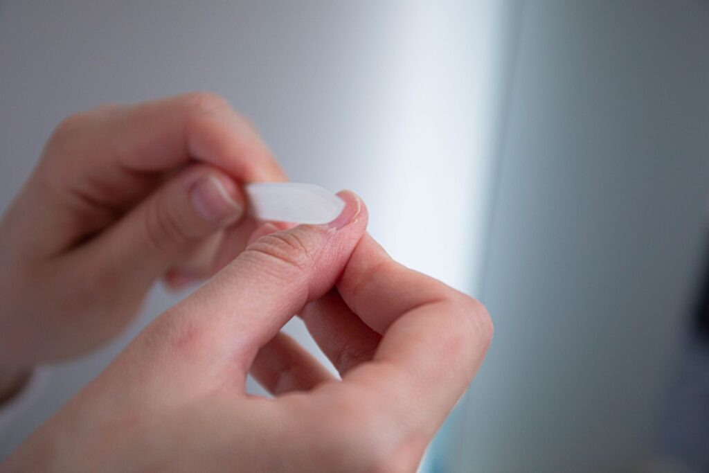 A detailed view of hands using a nail file for grooming purposes.