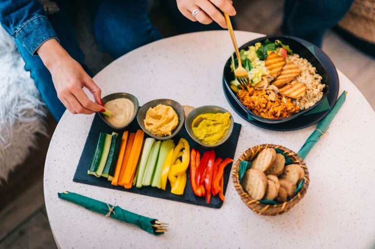 15 Déjeuners Healthy et Protéinés à Préparer Cette Semaine | Santé et bien-être Colorful display of healthy snacks with salad, hummus, and veggies on a table.