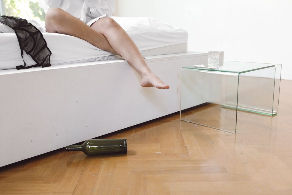 9 Habitudes Pour Réduire l’Apparence des Cernes au Quotidien | Santé et bien-être Relaxed morning after a party with wine bottle on wooden floor.